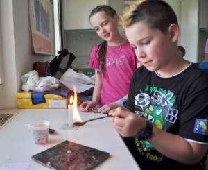 Was sie während der Woche bei der Sommerakademie "Sapientia ludens" ausprobiert haben - im Bild Flammenversuche - zeigen die Kinder der Grundschule zum Abschluss an diesem Freitag.