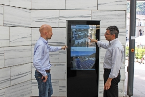 Der Direktor des Landesamts für Bauerhaltung Norberto Antonioni und der Direktor der Landesabteilung Hochbau und technischer Dienst Andrea Sega mit dem neuen Infopoint zu den Photovoltaik-Anlagen