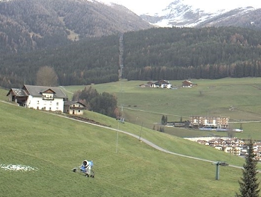 Eine Schneekanone in einer Landschaft ohne Schnee zeigt die in Meransen positionierte Webcam.