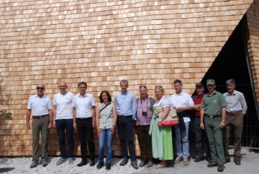 Landesrat Richard Theiner  und Architektin Christa Mair (3. u.4.v.l.) mit Vertretern von Gemeinde, Tourismusverein, Forst- und Domänenverwaltung und Baufirma vor dem markanten Schindeldach der Infostruktur.